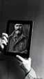 Placeholder: An old picture style of black and white mono very bad quality looks very old camera picture with cracks Pablo Picasso, War and Peace, holding an iPad, year 1900