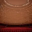 Placeholder: a single chair on stage under spotlight at a dark and empty symphony hall