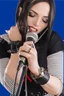 Placeholder: idealized female model country music singer leaning forward while holding microphone in one hand, other hand brought up to side of neck, change clothing to plaid in natural tones, leather bracelets on wrists, long hair, mouth open singing, rings on fingers, eyes closed