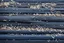 Placeholder: small clusters of tiny sand grains spread out over Navy Blue driftwood planks Background