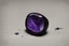 Placeholder: небольшое чёрное кольцо с лиловым камнем на нем выпало на пол.