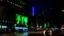 Placeholder: a billboard branded writing ODK , with neon light green and white , in the city center, at night . At Montréal