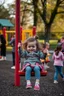 Placeholder: a 40 year old dad in the playground with his young 3 year old daughter playing on the swing but the dad is distracted by all the other kids curvy mums and loses his child. there are many kids playing on the playground
