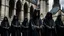 Placeholder: hooded monks in black robes in front of cathedral