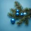 Placeholder: a branch of a Christmas tree on a blue background with blue Christmas toys