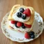 Placeholder: A full-view image of Mille-Feuille, delicate layers of puff pastry, cream, and fresh berries, served on a fine china plate.