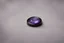 Placeholder: небольшое чёрное кольцо с лиловым камнем выпало на пол.