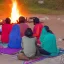 Placeholder: mystical indian woman in sari teaching her group of disciple in adoration in himalaya, around a fire at sunrise