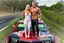 Placeholder: make a pic with short hair bodybuilder Knut Spildrejorde from Norway and his fitness wife Jeanette, they are standing front of his new red car Chevrolet Camaro, very busy highway in sunny Texas in the background