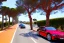 Placeholder: Day in quinta do lago, main avenida with two luxury car, with red cycling lane on both sides