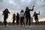 Placeholder: a group of Turkish young ladys in sports pants and blouse are dancing in Babak Castle in Iran west north ,cloudy sun set sky