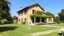 Placeholder: big beautiful country side villa with a large garden and grass and flowers in front and stone pavements