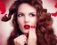 Placeholder: Beautiful portrait female, long brown wavy hair, barrel roll curls, looking down and to the side, full red lips, hand up like blowing a kiss, side profile