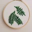 Placeholder: ferns in embroidery hoop, intricate, detailed, delicate, extremely beautiful