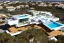 Placeholder: Day in algarve quinta do lago, aerial architectural view, modern luxury villas architecture building WITH STRAIGHT LINES AND CANNOPY in white render and wood with cannopy in gold metallic details and a modern luxury hotel building with two floors and extending covered terraces cascading, pinus pinea overlooking the golf course, green roofs and pools, sloped land with pinus pinea, hyper realistic 8k ultra render