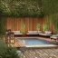 Placeholder: a gorgeous, stunning garden deck with wood walls, rustic floor, wicker furniture, string of illuminated globes, tranquil pool surrounded by smooth stones, lit candles, foliage, cozy, 8k resolution, high-quality, fine-detail, zen-like, digital art, detailed matte, volumetric lighting, illustration, 3D octane render, brian froud, howard lyon, selina french, annie stokes, lisa parker, greg rutowski