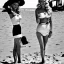 Placeholder: Brigitte Bardot on the beach in a 1940's style retro outfit. Paparazzi taking photos