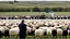 Placeholder: George w bush at podium speaking to large field of sheep